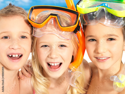 Photo: Portrait of the happy children enjoying at beach Portrait of the happy children enjoying at beach