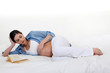 Pregnant woman reading in bed