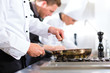 Photo: Three chefs in team in hotel or restaurant kitchen Three chefs in team in hotel or restaurant kitchen