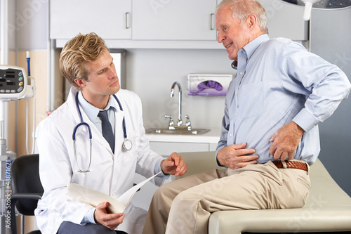 Photo: Doctor Examining Male Patient With Hip Pain Doctor Examining Male Patient With Hip Pain