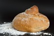 Буханка хлеба с мукой на черном фоне