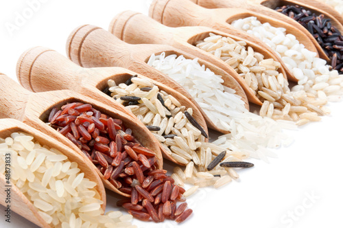 Photo: Wooden scoops with different rice types scattered from them Wooden scoops with different rice types scattered from them