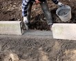 Construction site - Worker laying concrete curbs