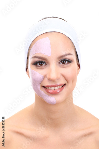 Photo: Young woman with clay facial mask, isolated on white Young woman with clay facial mask, isolated on white