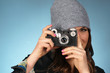 Hip Woman Snaps a Picture of Viewer with Vintage Camera
