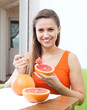   woman eating grapefruit at home