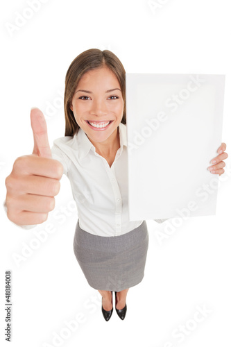 Photo: Business woman giving thumb up with copyspace sign Business woman giving thumb up with copyspace sign