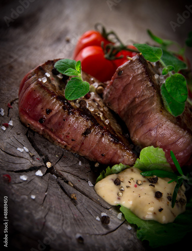 Photo: Grilled bbq steaks with fresh herbs and tomatoes Grilled bbq steaks with fresh herbs and tomatoes