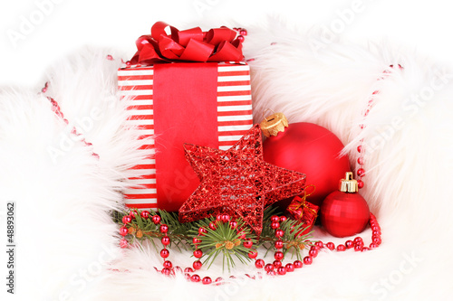 Photo: Christmas gift and red christmas balls in white fur Christmas gift and red christmas balls in white fur