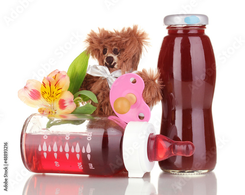 Photo: Baby bottle with fresh juice and teddy bear isolated on white Baby bottle with fresh juice and teddy bear isolated on white