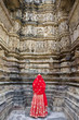 Woman in red sari at Khajuraho Temple.