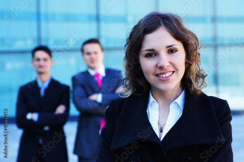 Photo: A young businesswoman standing in front of her colleagues A young businesswoman standing in front of her colleagues