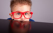 Photo: Five years old little cute boy hiding behind a table Five years old little cute boy hiding behind a table