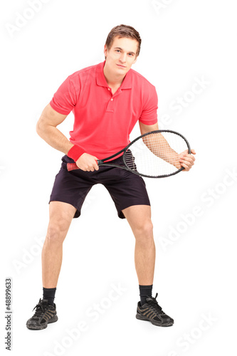 Photo: Full length portrait of a male tennis player holding a racket Full length portrait of a male tennis player holding a racket