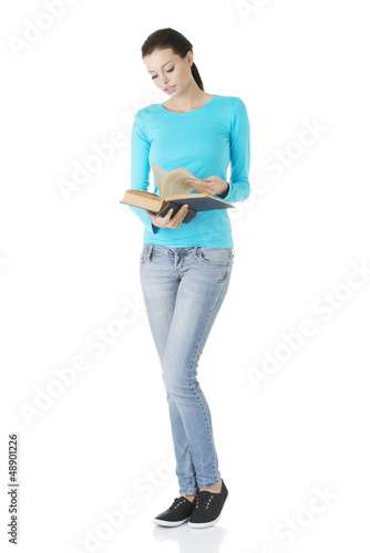 Photo: Young focused female reading book Young focused female reading book