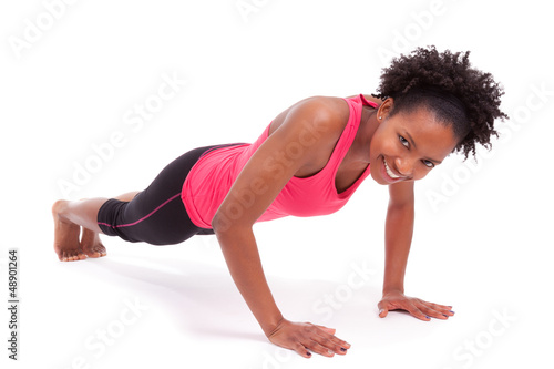 Photo: Young beautiful african fitness woman doing push up exercises on Young beautiful african fitness woman doing push up exercises on
