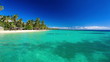 Few palm trees over tropical lagoon with white beach