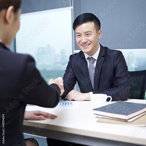 Photo: asian business people shaking hands in office asian business people shaking hands in office