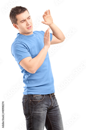 Photo: Young man defending himself with hands up Young man defending himself with hands up