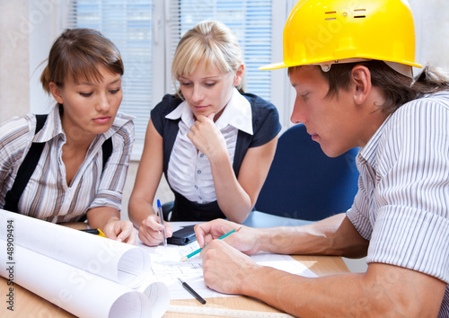 Photo: team of engineers working on construction project team of engineers working on construction project