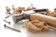 hammer and nails on a wood board with sawdust shavings