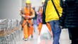Workers walk among people in cafe, unfocused view