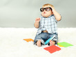 Little boy with multicolor books, on white carpet