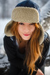 Portrait of a smiling beautiful young woman in a earflap-hat