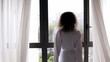 Woman comes to draws curtains and walks away, street traffic