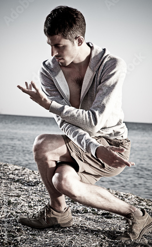 Photo: Young attractive man making Thai-chi movements Young attractive man making Thai-chi movements