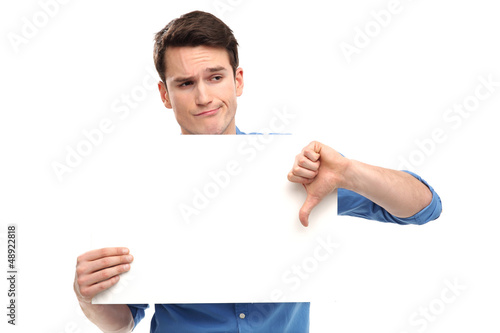 Photo: Man showing thumbs down with blank board Man showing thumbs down with blank board