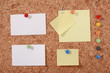 Several message papers pinned to cork board