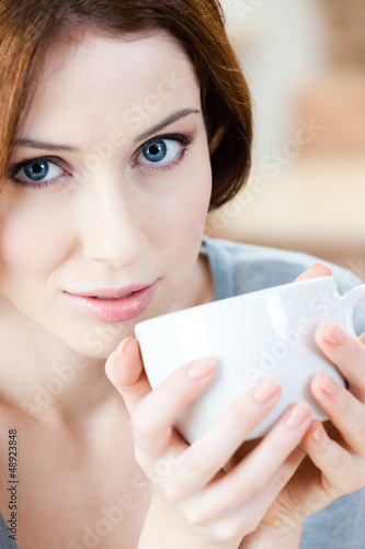 Photo: Woman with cup of tea has a rest at the cafeteria Woman with cup of tea has a rest at the cafeteria