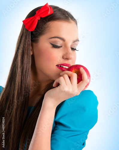 Photo: Young beautiful woman in blue holding a red apple Young beautiful woman in blue holding a red apple