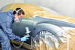 Worker painting a car.