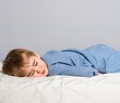 Foto: Little boy in blue pyjamas sleeping in bed Little boy in blue pyjamas sleeping in bed