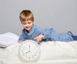 Photo: Little boy in blue pyjamas with clock Little boy in blue pyjamas with clock
