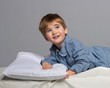 Playful little boy wearing blue pyjamas in bed