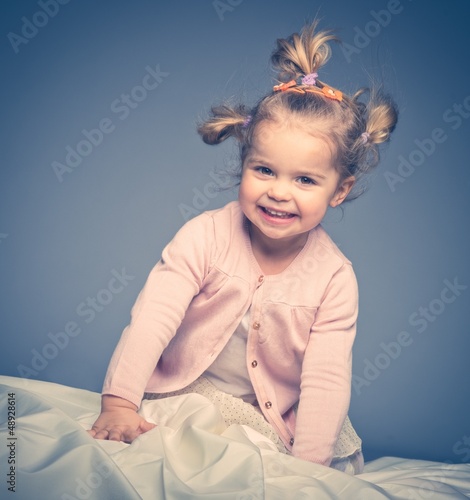 Photo: Little girl having fun on bed Little girl having fun on bed
