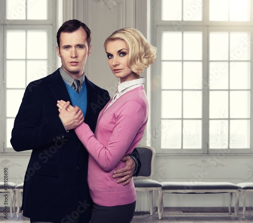 Photo: Elegant couple indoors standing near window Elegant couple indoors standing near window