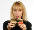 Attractive woman holding wrapped present surprised expression