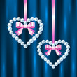 Pearl hearts with pink ribbons and bows on dark blue silk