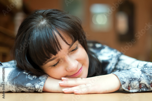 Photo: brunette girl sleeps on table brunette girl sleeps on table