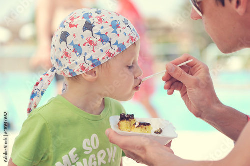 Photo: Father feeding son delicious dessert spoon Father feeding son delicious dessert spoon