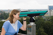 Young woman looking through a telescope