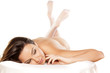 Beautiful nude brunette lying on a white bed on white background