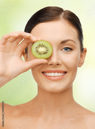 Photo: woman with kiwi slice woman with kiwi slice