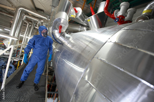 Photo: Technician in blue uniform checking technological system Technician in blue uniform checking technological system