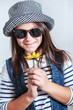 Attractive young girl in cap with a flower in hands