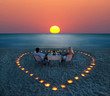 A young couple share a romantic dinner on the beach
